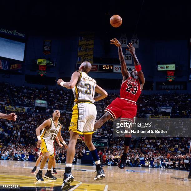 Michael Jordan of the Chicago Bulls shoots a jump shot over Reggie Miller of the Indiana Pacers in Game Six of the Eastern Conference Finals during...