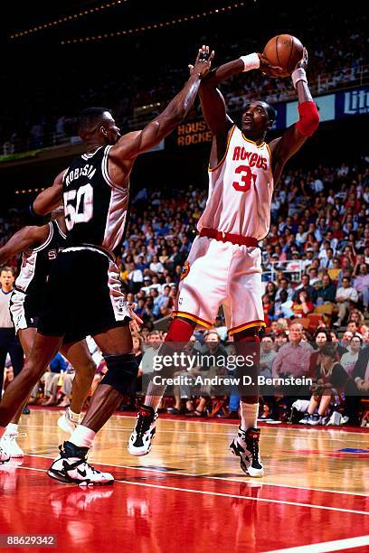 Hakeem Olajuwon of the Houston Rockets shoots a jump shot against David Robinson of the San Antonio Spurs in Game Three of the Western Conference...