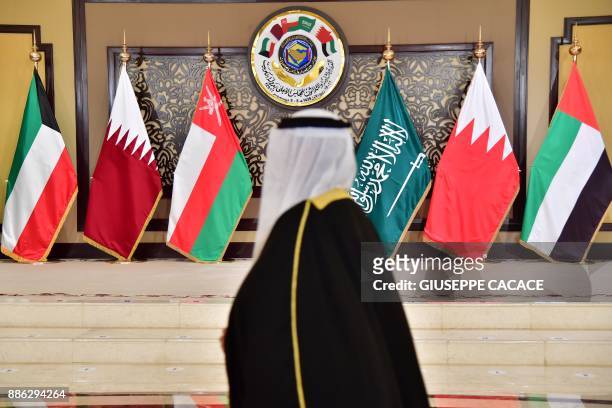 Man walks past the flags of the countries attending the Gulf Cooperation Council summit at Bayan palace in Kuwait City on December 5, 2017. The Gulf...