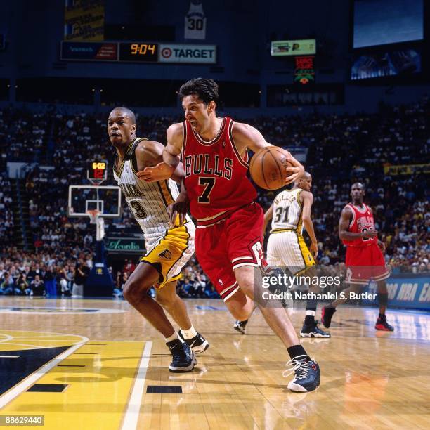 Toni Kukoc of the Chicago Bulls drives to the basket against Antonio Davis of the Indiana Pacers in Game Six of the Eastern Conference Finals during...