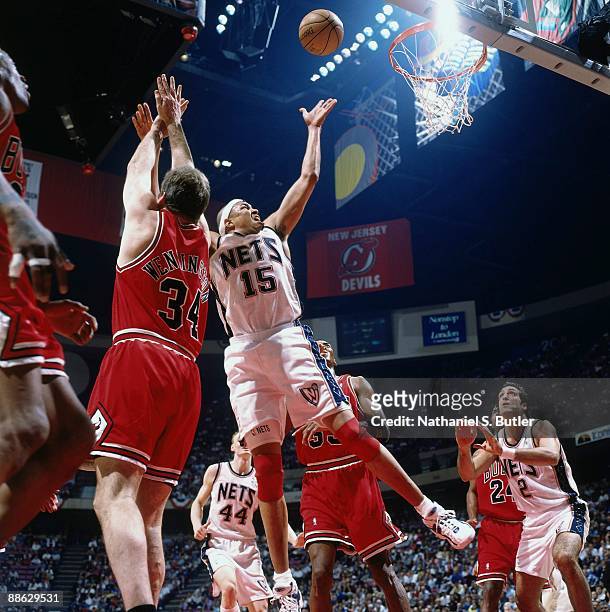 Chris Gatling of the New Jersey Nets shoots against Bill Wennington of the Chicago Bulls in Game Three of Eastern Conference Quarterfinals during the...