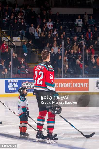 The Pepsi player of the game stands on the blue line and looks up at Braydyn Chizen of the Kelowna Rockets during the national anthem against the...