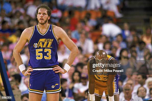 Mark Eaton of the Utah Jazz stands next to Kareem Abdul-Jabbar of the Los Angeles Lakers during an NBA game at The Salt Palace in Salt Lake City,...