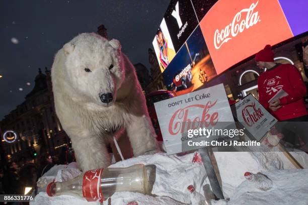 Greenpeace activists hold a demonstration in front of the Piccadilly Circus electronic billboard as part of a global campaign to get Coca Cola to...