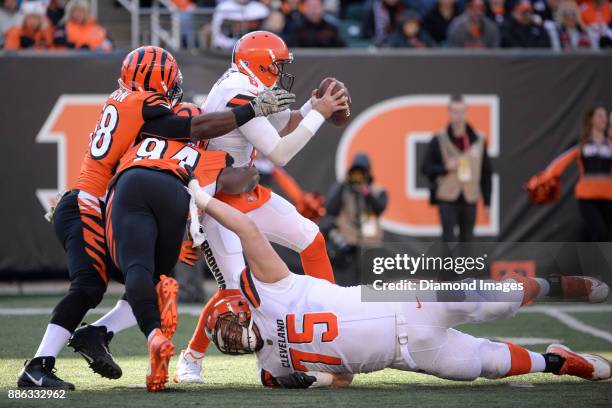 Quarterback Cody Kessler of the Cleveland Browns is sacked by linebacker Carl Lawson and defensive end Chris Smith of the Cincinnati Bengals in the...