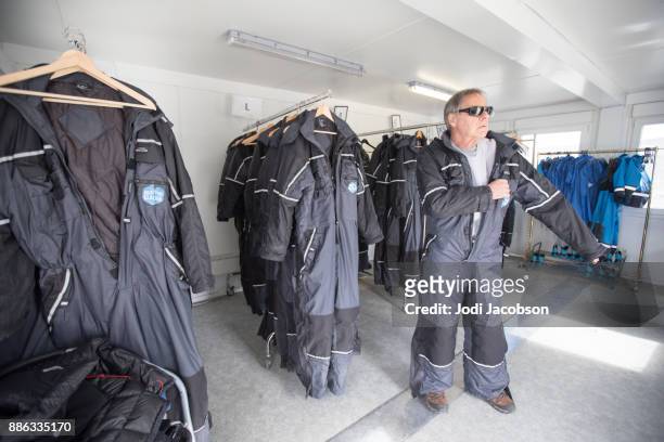 man getting dressed for tour of langjokull glacier in iceland. - langjokull stock pictures, royalty-free photos & images