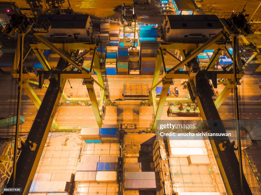 Harbor crane being Loading on container ship in warehouse port at night .