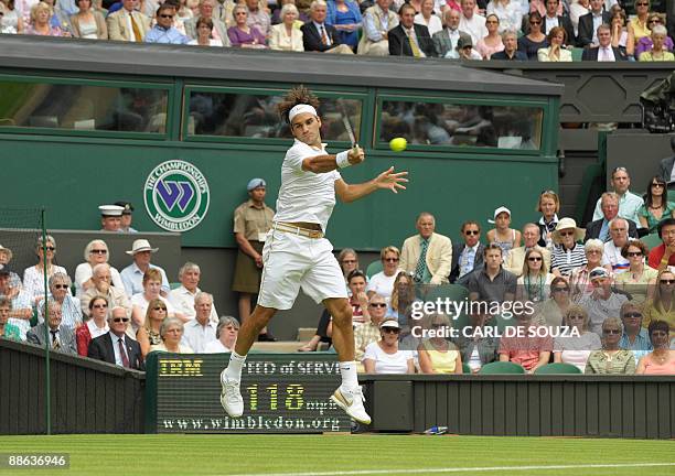 Switzerland's Roger Federer returns a ball to Taiwan's Yen-Hsun Lu during their first round match of the 2009 Wimbledon tennis championships at the...