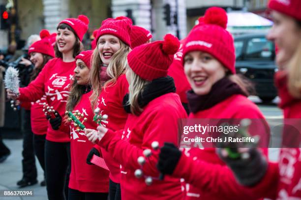 Greenpeace activists sing as they hold a demonstration in front of the Piccadilly Circus electronic billboard as part of a global campaign to get...