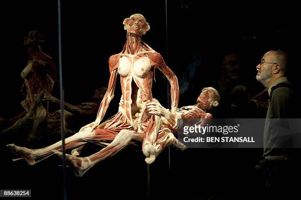 Visitor looks at a sculpture by German "plastinator" Gunther von Hagens during a press conference as he unveils his new sex plastinates for his Body...