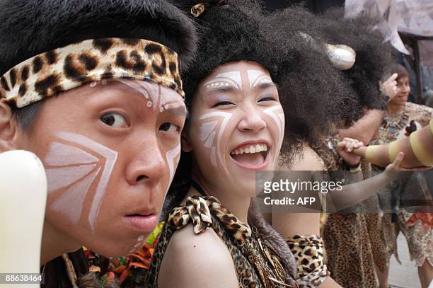 Dancers dressed as cavemen perform at the opening of a prehistoric themed attraction at the Ocean Park theme park in Hong Kong on June 23, 2009. The...