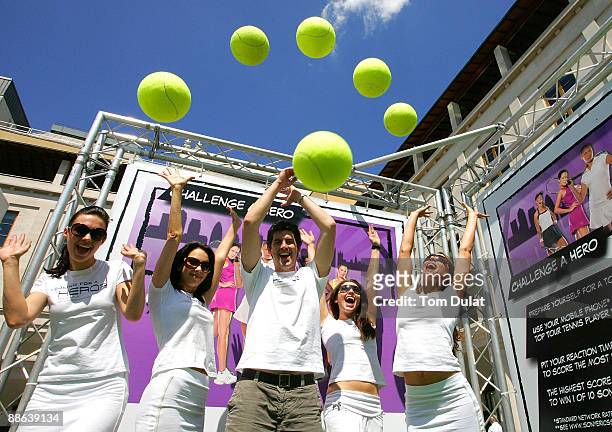 Staff throw balls in the air to celebrate an interactive mobile tennis game on a giant plasma screen during which passers by can challenge No 7 Vera...