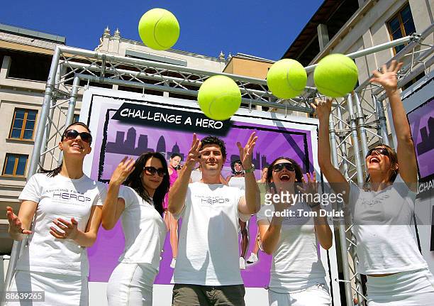 Staff throw balls in the air to celebrate an interactive mobile tennis game on a giant plasma screen during which passers by can challenge No 7 Vera...