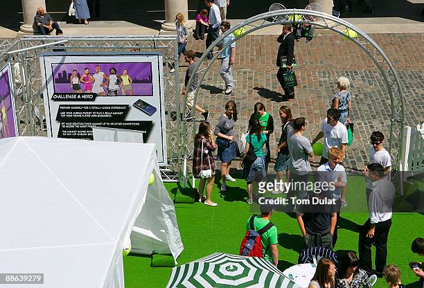 People arrive to challenge World No 7 Vera Zvonareva in an interactive mobile tennis game on a giant plasma screen during the WTA live digital gaming...