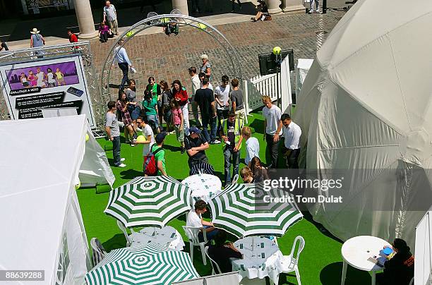 People arrive to challenge World No 7 Vera Zvonareva in an interactive mobile tennis game on a giant plasma screen during the WTA live digital gaming...