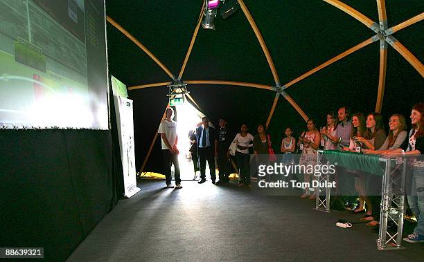 Group of fans are challenged by World No 7 Vera Zvonareva in an interactive mobile tennis game on a giant plasma screen during the WTA live digital...