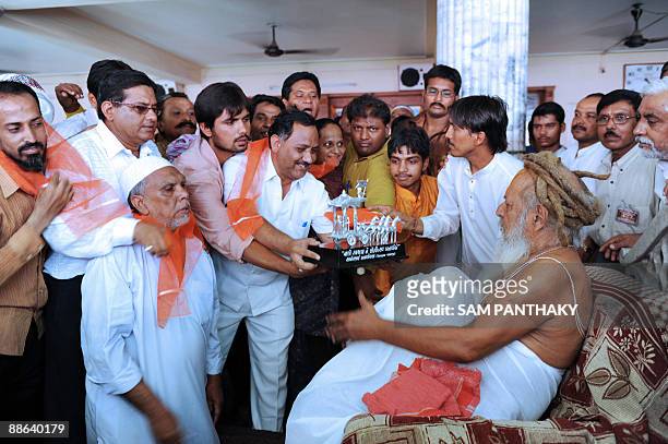 Indian Muslims offer a momento to the head priest of the Lord Jagannath mandir, Mahant Shree Rameshwar Dasji in Ahmedabad on June 23, 2009 the eve of...