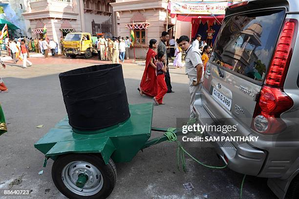 An Indian security guard keeps vigil as a Bomb Removal Basket attached to a special vehicle is kept ready prior to the visit by Gujarat state Chief...