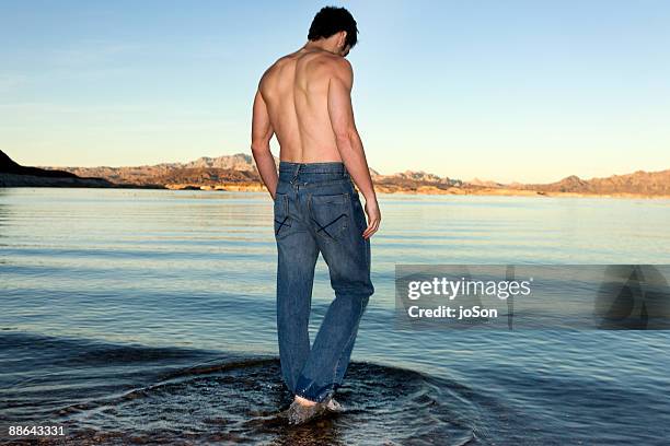 young man standing in shallow water in lake mead - ankle deep in water fotografías e imágenes de stock