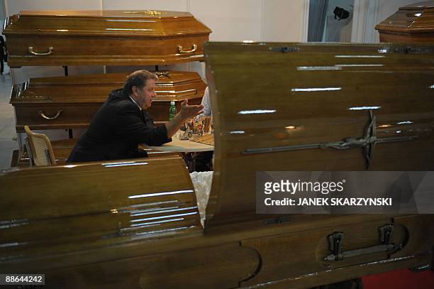 Salesman working for a coffin company talks to a customer as coffins are on display, during NecroExpo, a trade fair for Poland's flourishing funeral...