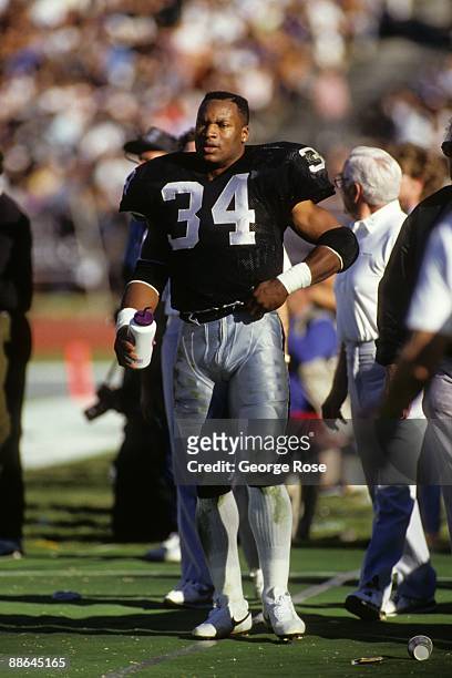 Running back Bo Jackson of Los Angeles Raiders stands on the sidelines during the 1990 AFC Divisional Playoffs against the Cincinnati Bengals at the...
