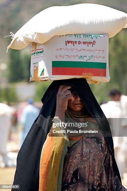 Pakistani caries food handouts from military sponsored food distribution, during a media visit to the area June 23, 2009 in Buner district, Pakistan....