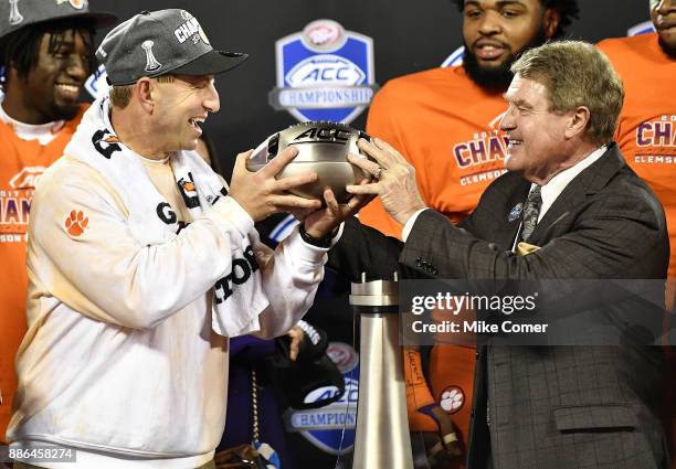 Head coach Dabo Swinney of the Clemson Tigers accepts the ACC Football Championship trophy from ACC Commissioner John Swofford following the Tigers'...