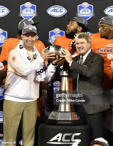 Head coach Dabo Swinney of the Clemson Tigers accepts the ACC Football Championship trophy from ACC Commissioner John Swofford following the Tigers'...