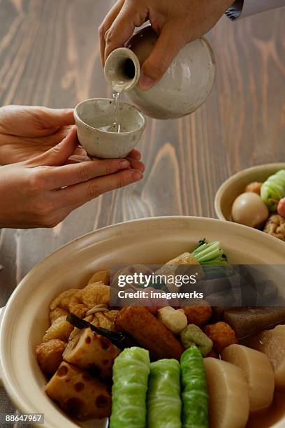 man pouring sake into sake cup - cabbage roll stock pictures, royalty-free photos & images