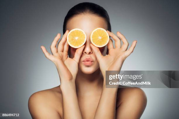 girl with two parts of lemon - lemon fruit stock pictures, royalty-free photos & images