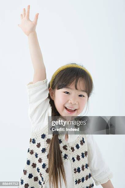 japanese girl (6-7 years) raising hand, smiling - 6 7 years - fotografias e filmes do acervo