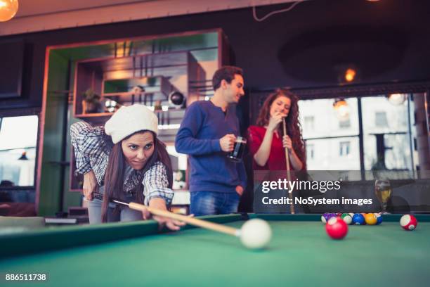 freunde, die einen spaß beim spielen billard in einer kneipe. - anstossen stock-fotos und bilder