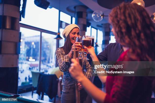 friends having a fun while playing billiard in a pub, toasting with beer. - snooker break stock pictures, royalty-free photos & images