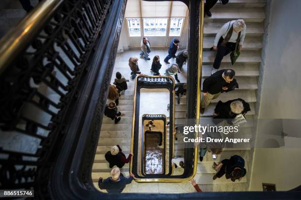 Activists rallying against the GOP tax reform bill make their way through the Cannon House Office building on Capitol Hill, December 5, 2017 in...