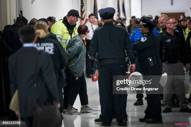 An activist who was protesting agains the GOP tax reform bill is arrested by Capitol Police officers, outside the office of Rep. Dana Rohrabacher on...