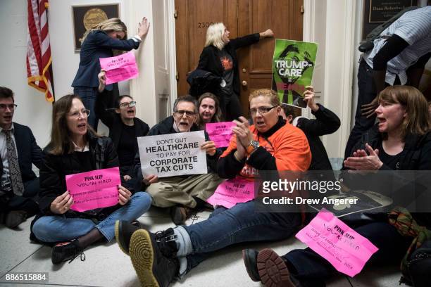 Activists stage a sit-in to protest the GOP tax reform bill, outside of office of Rep. Dana Rohrabacher on Capitol Hill, December 5, 2017 in...