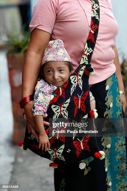 Khagendra Thapa Magar, 15 and a half, fits into a handbag held by held by his mother Dhan Maya on March 13, 2007 in Pokhara, Nepal. According to the...