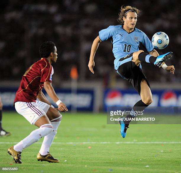 Carlos Salazar of Venezuela vies for the ball with Diego Forlan of Uruguay during their FIFA World Cup South Africa-2010 qualifier football match at...