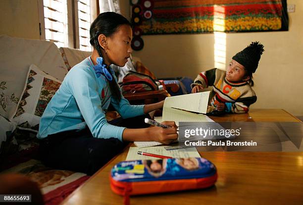 Khagendra Thapa Magar, 15 and a half, talks with Sabina while she does her homework on March 13, 2007 in Pokhara, Nepal. According to the Guinness...
