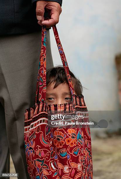 Khagendra Thapa Magar, 15 and a half, fits into a handbag held by his manager Min Bahadur Rana Magar on March 13, 2007 in Pokhara, Nepal. According...