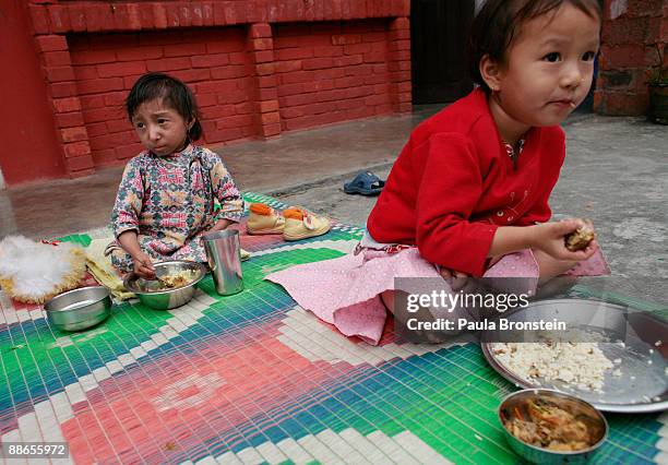 Khagendra Thapa Magar, 15 and a half, eats his lunch along side family friend Binita who is 4 years old on March 13, 2007 in Pokhara, Nepal....