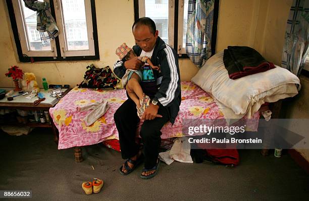 Khagendra Thapa Magar, 15 and a half, gets changed by his father, Rup Bahadur inside their bedroom on March 13, 2007 in Pokhara, Nepal. According to...