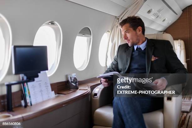 man in prive-jet vliegtuig - business travel stockfoto's en -beelden