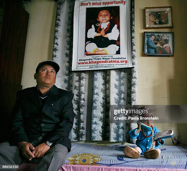 Khagendra Thapa Magar, 15 and a half, talks on a phone as manager Min Bahadur Rana Magar listens on March 13, 2007 in Pokhara, Nepal. According to...
