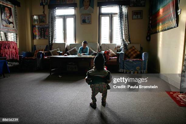 Khagendra Thapa Magar, 15 and a half, enters the living room watching Sabina doing homework on March 13, 2007 in Pokhara, Nepal. According to the...
