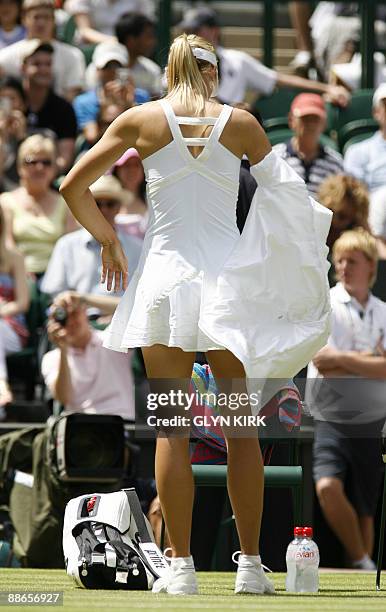 Russia's Maria Sharapova takes her jacket off as she prepares to plays against Argentina's Gisela Dulko at the All England Tennis Club on the third...