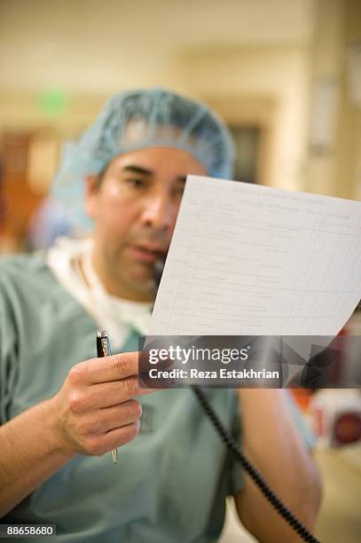 doctor reads patient notes over telephone - glendale california stock pictures, royalty-free photos & images