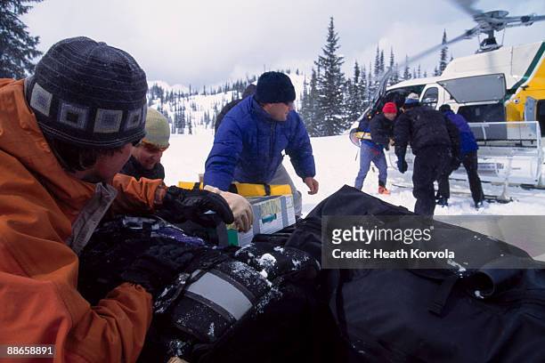 backcountry skiers unpacking helicopter. - nelson british columbia stock pictures, royalty-free photos & images