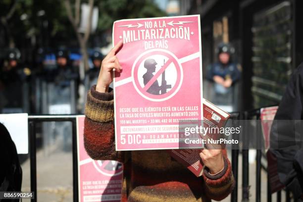 Activists hold banners against a law that militarises crime fighting in the country outside the Senate in Mexico City, Mexico December 5, 2017....