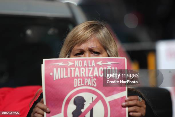 Activists hold banners against a law that militarises crime fighting in the country outside the Senate in Mexico City, Mexico December 5, 2017....